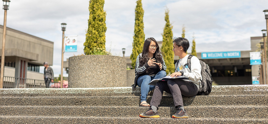  North Seattle College students sitting on front steps 