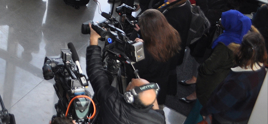  media cameras at a press conference 