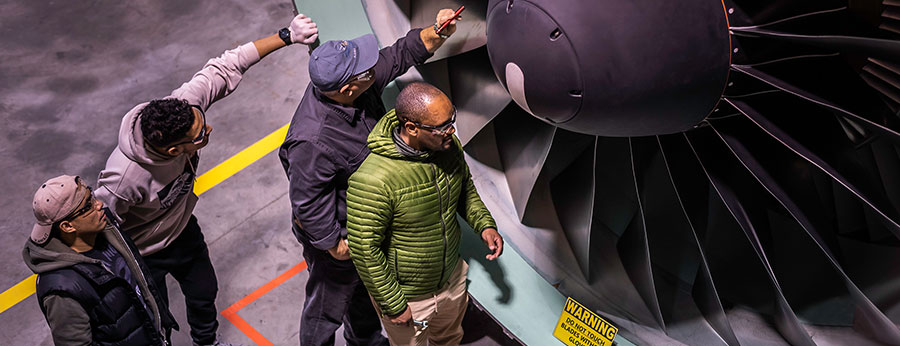 South Seattle College students in aeronautical class with plane wing