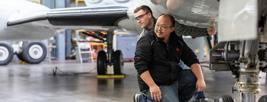  South Seattle College students in aviation class under a plane wing 