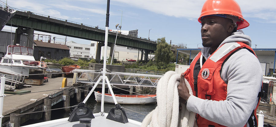 student holding rope on the deck of a boat
