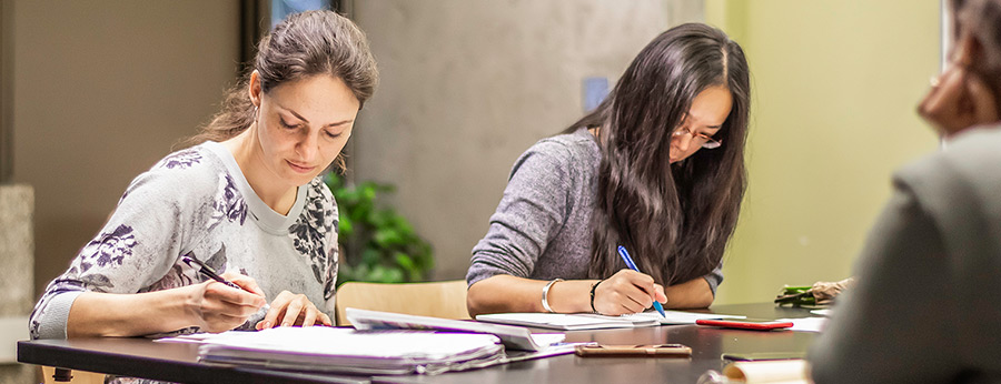 North Seattle College students working together taking notes in class