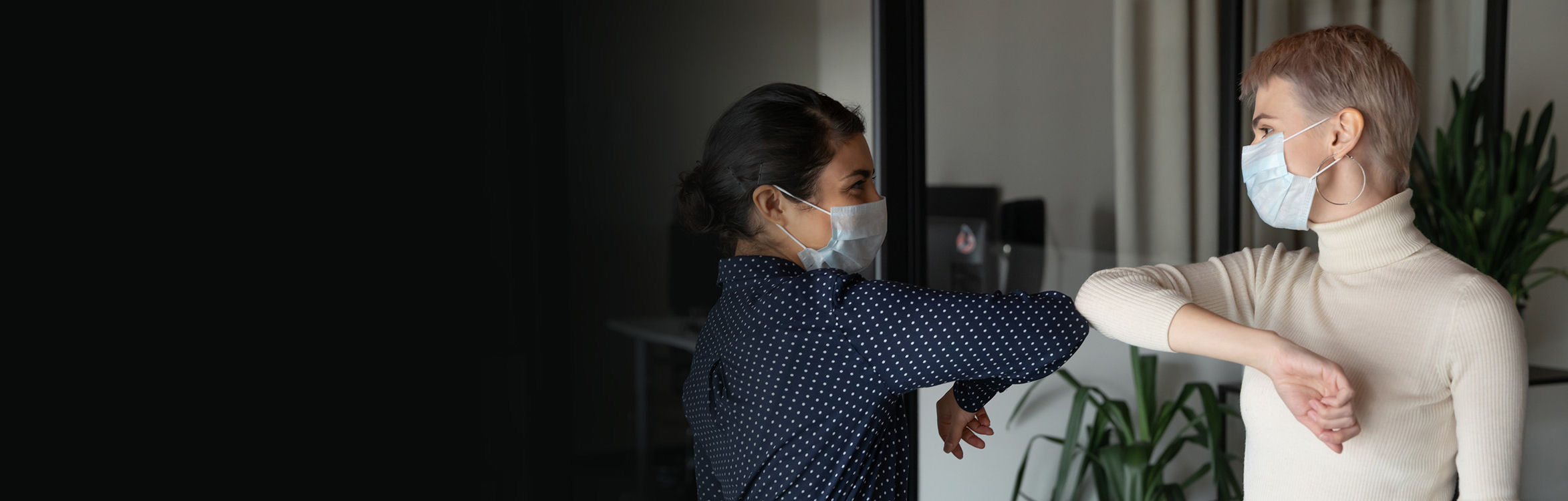  two women wearing face masks to help prevent COVID-19 