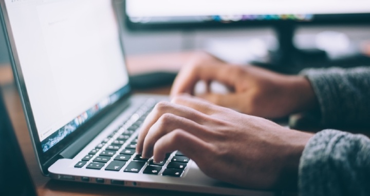  hands typing on a laptop computer 