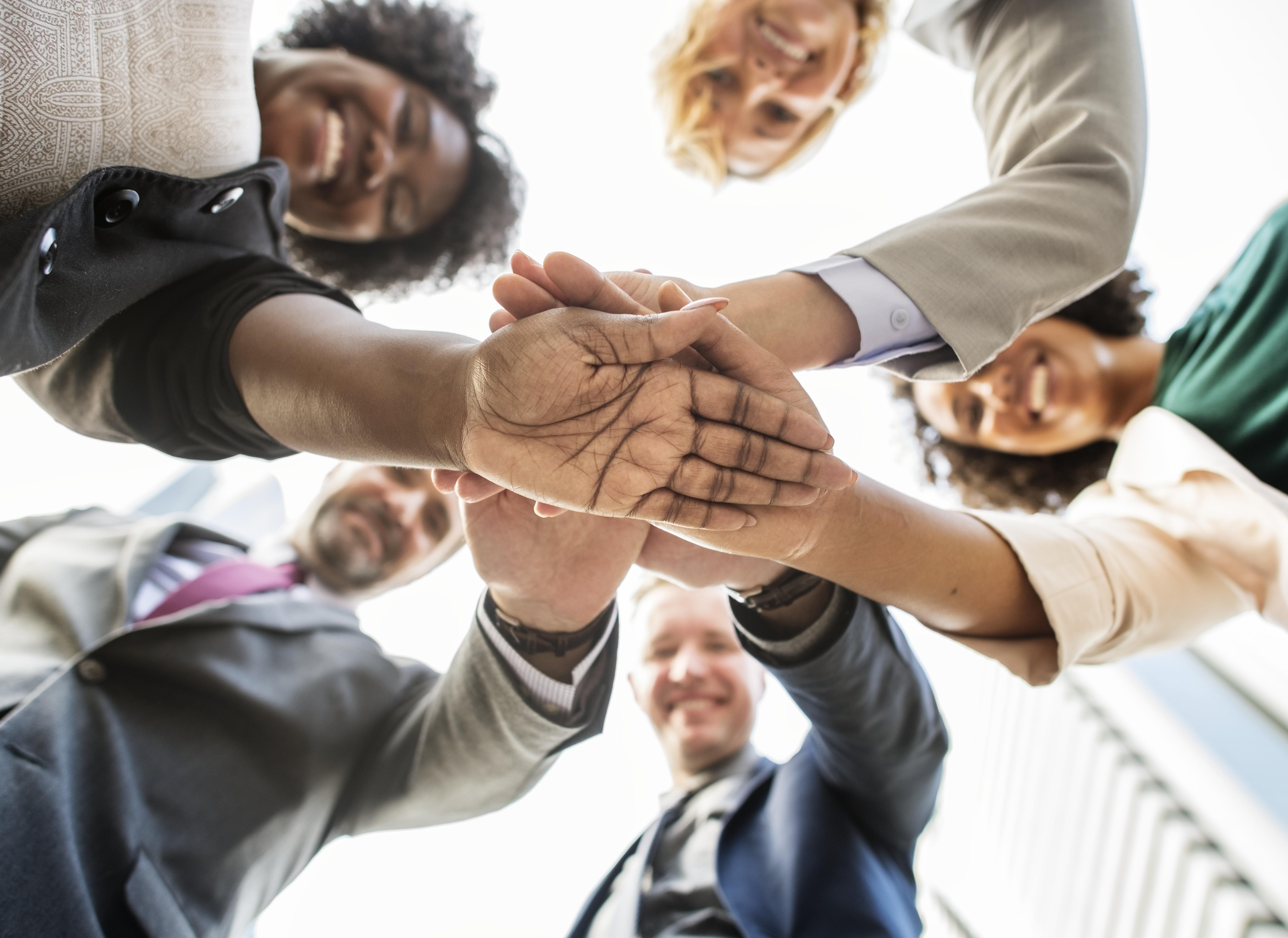  people doing a team gesture touching hands 