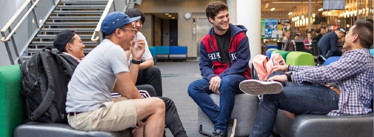  A group of students in a lounge area talking and laughing 