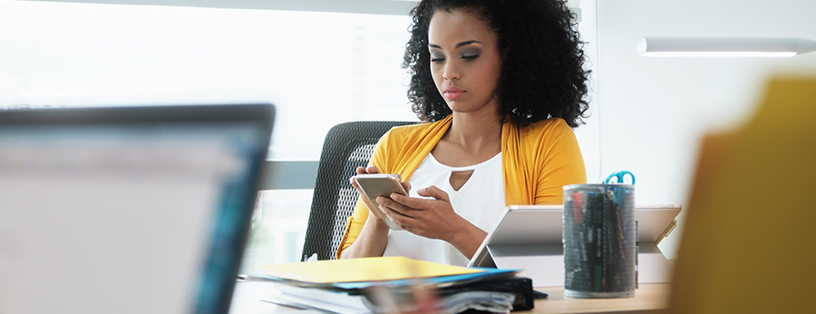  Woman sitting at conference table looking at phone 