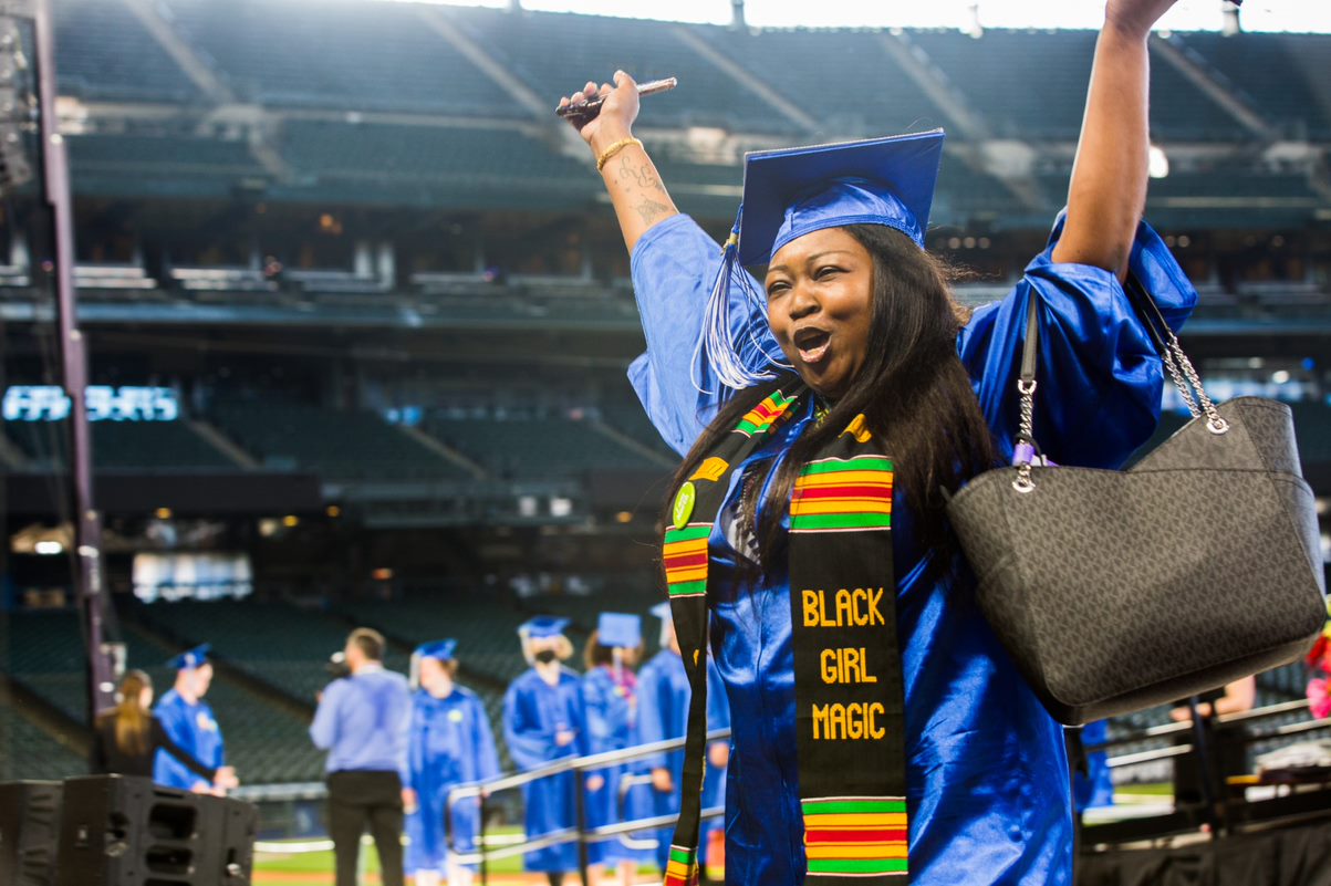 student celebrating her walk across the commencement stage