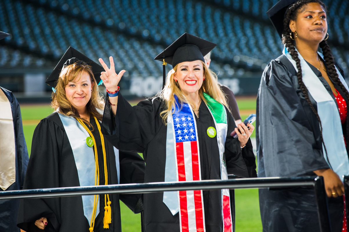 three students just about to walk across the stage