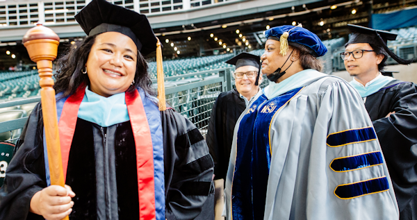  Interim Chancellor Rosie Rimando-Chareunsap holding the academic mace with other college officials at commencement 