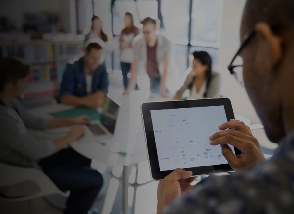  Students in classroom in the background closeup of person on tablet 