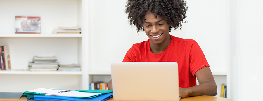  Student on a computer smiling 