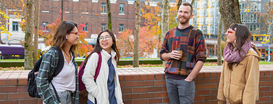 four students smiling and talking on the Seattle Central Campus