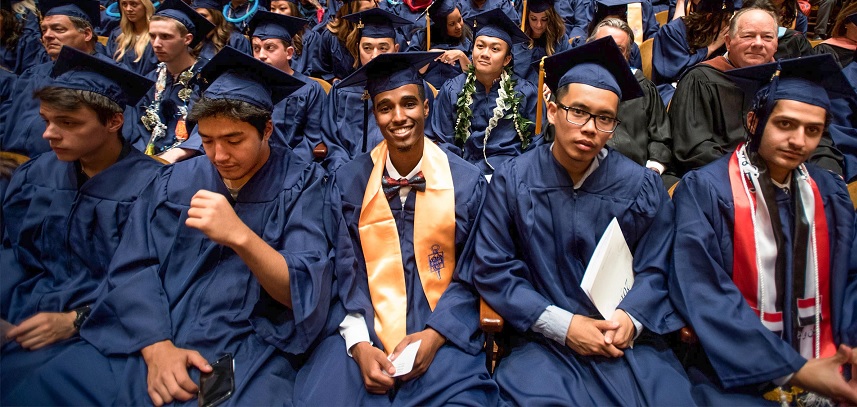 A group of students wearing caps and gowns at commencement