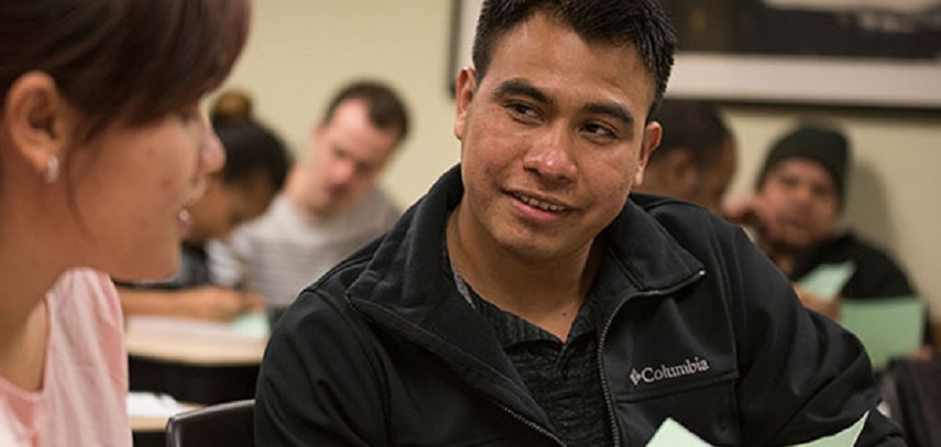 A student helping another student in a classroom setting