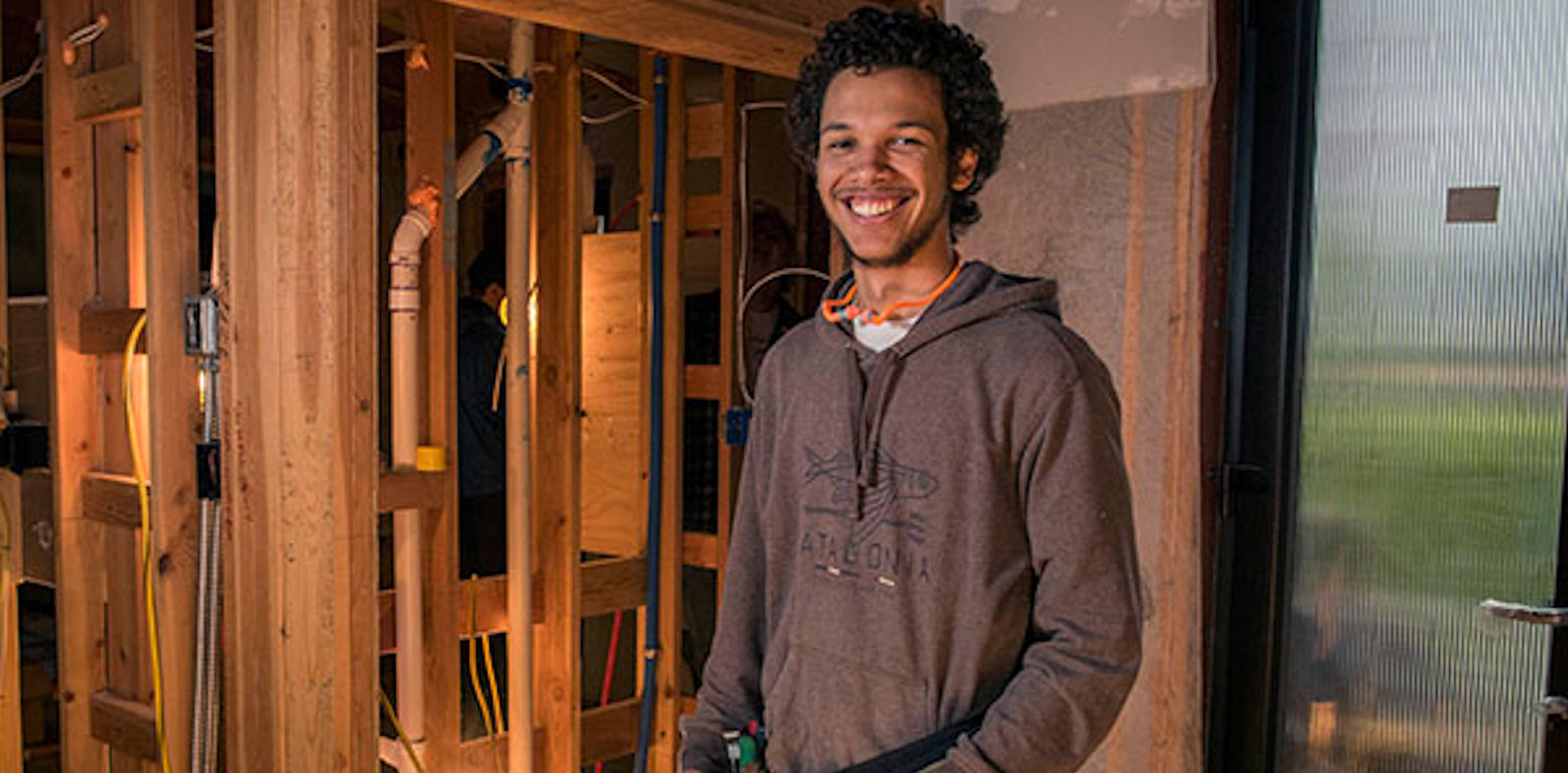 smiling student at the Wood Technology Center in a construction setting
