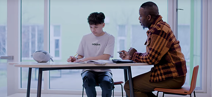 a student and teacher working together at a table