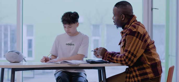 a student and teacher working together at a table
