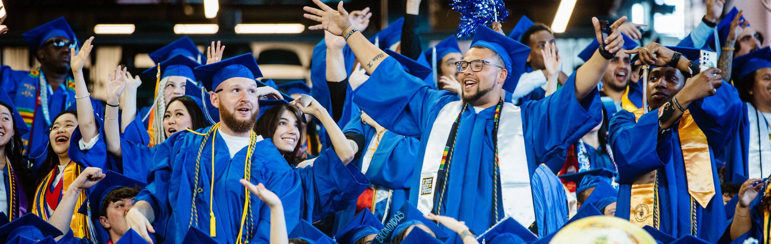 a group of smiling students in caps and gowns at commencement