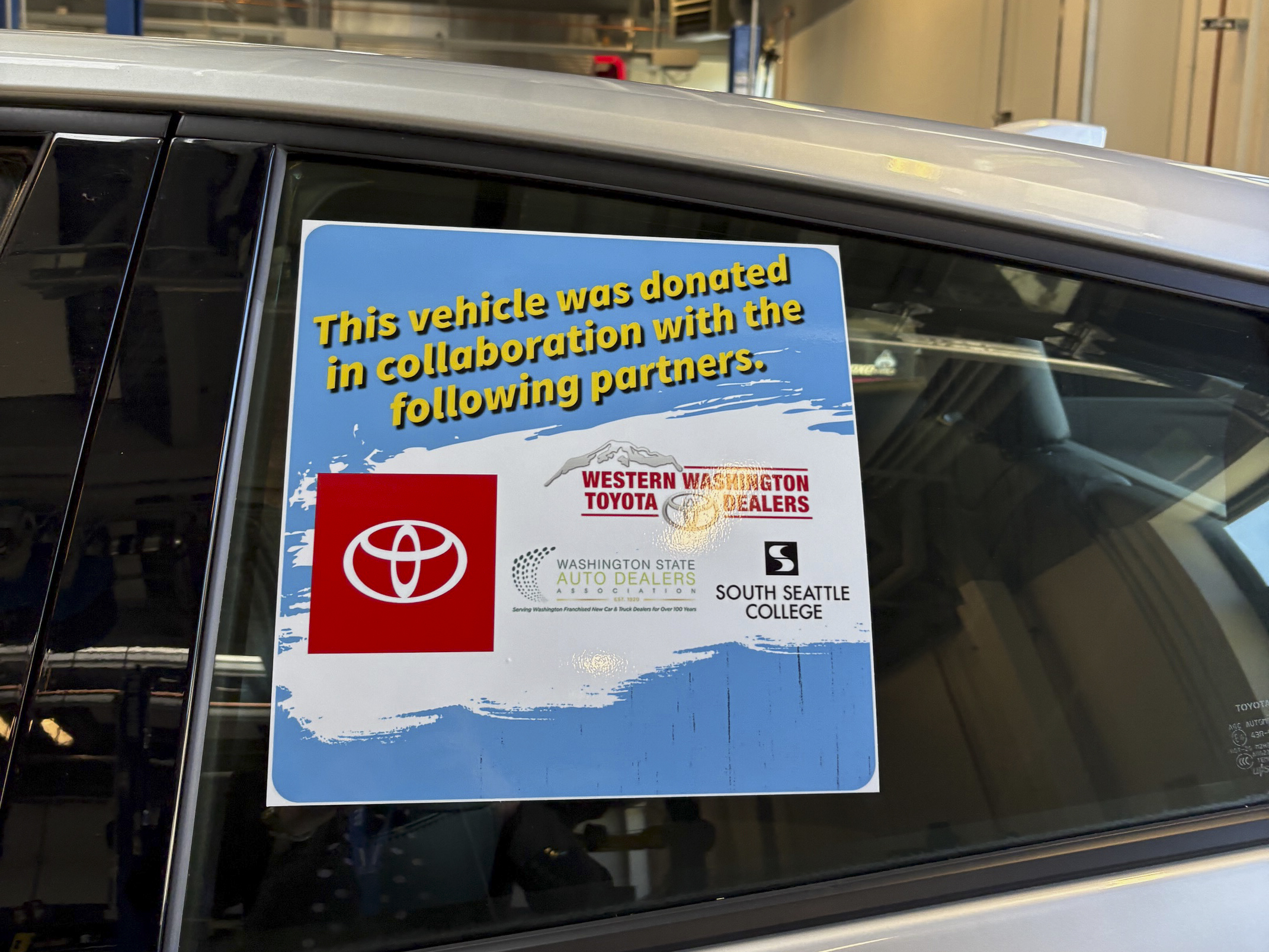 Sticker on the Toyota Prius Prime depicting the partners whose collaboration resulted in the donation of the vehicle: Western Washington Toyota Dealers, Washington State Auto Dealers Association, Toyota North America and South Seattle College.