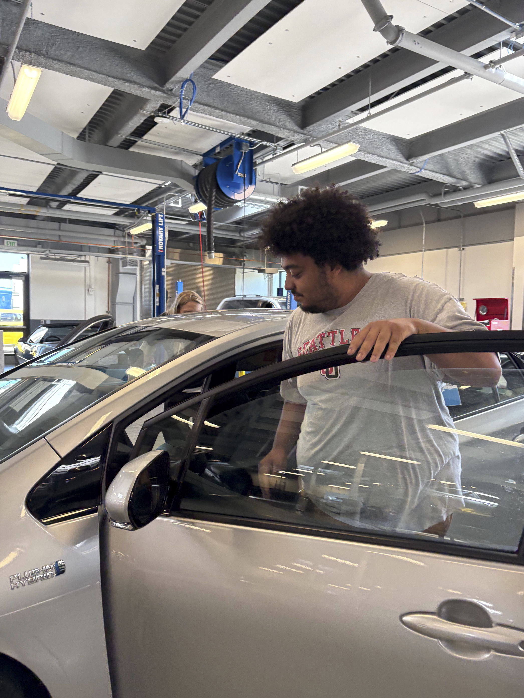 South Seattle College student admiring the newly donated Toyota Prius Prime.