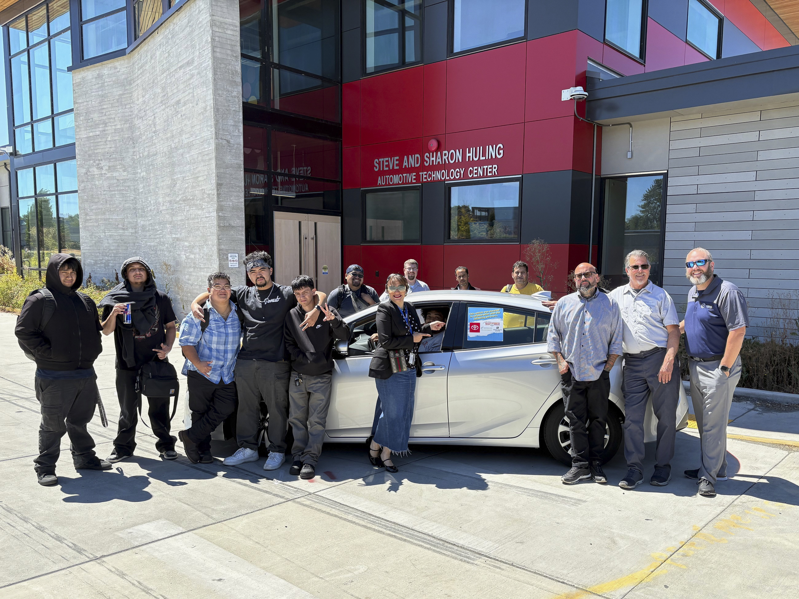 Toyota representatives along with South Seattle College and Seattle Colleges leadership, together with students receiving the Toyota Prius Prime to enhance EV and Hybrid battery-powered vehicle training.