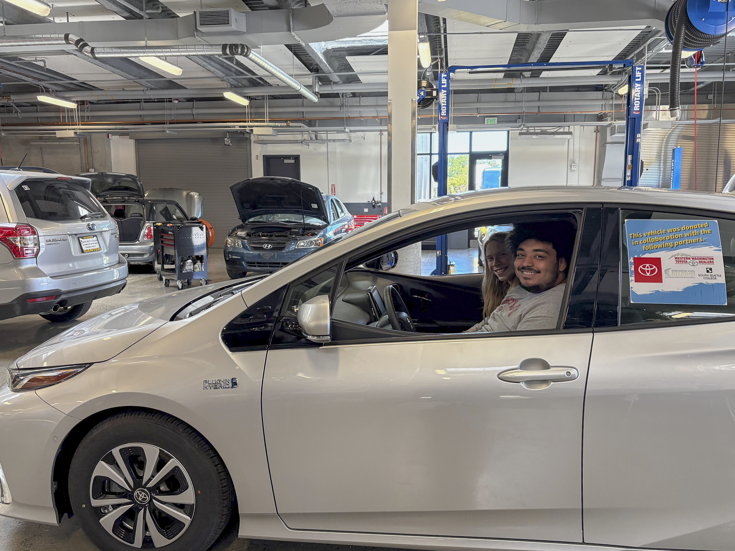 South Seattle College student aboard the newly donated Toyota Prius Prime.