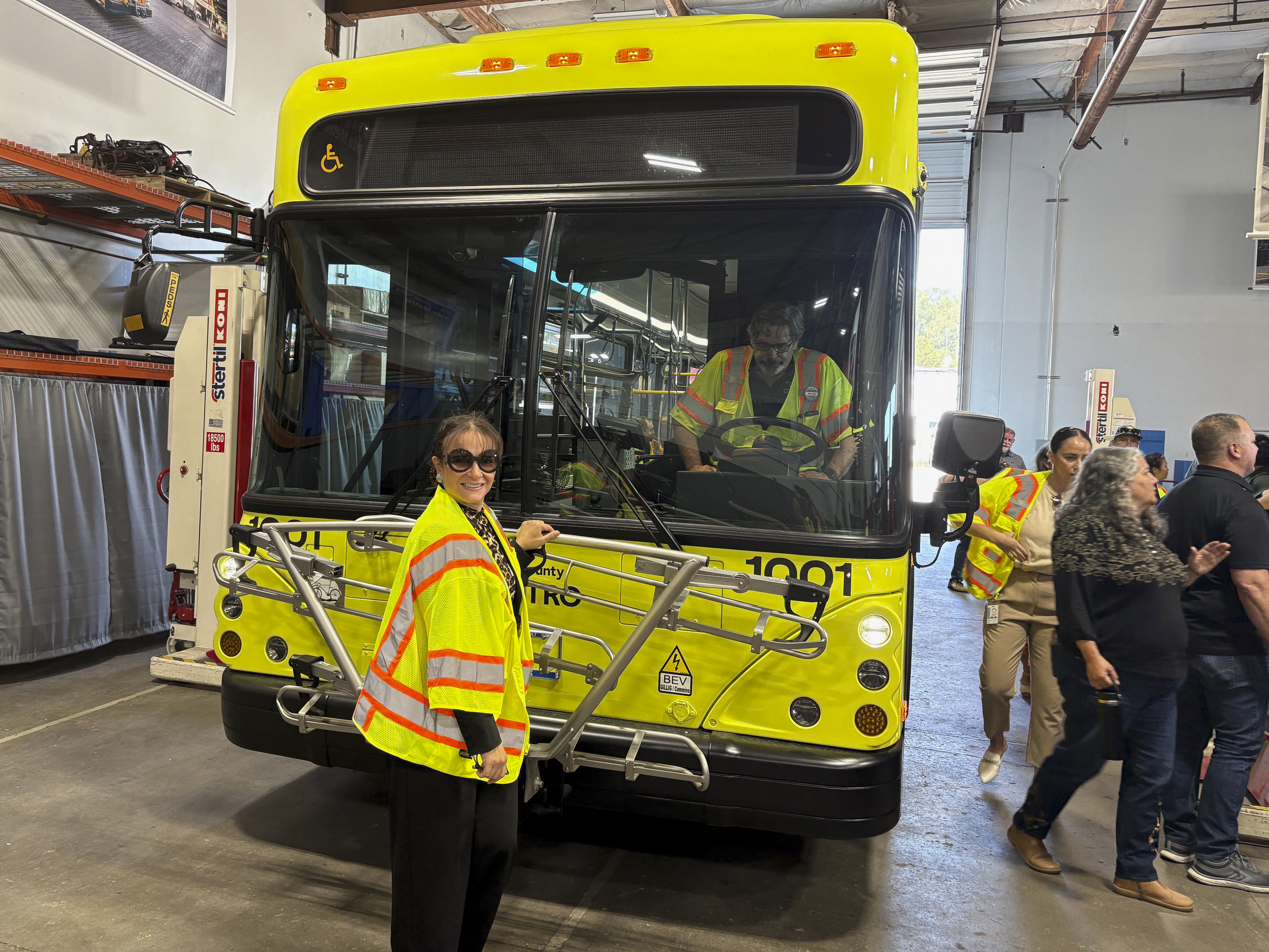 Dr. Dalia Sherif (Senior Executive Director of Seattle Colleges District Workforce Development Office) next to one of King County Metro's zero-emissions fleet.