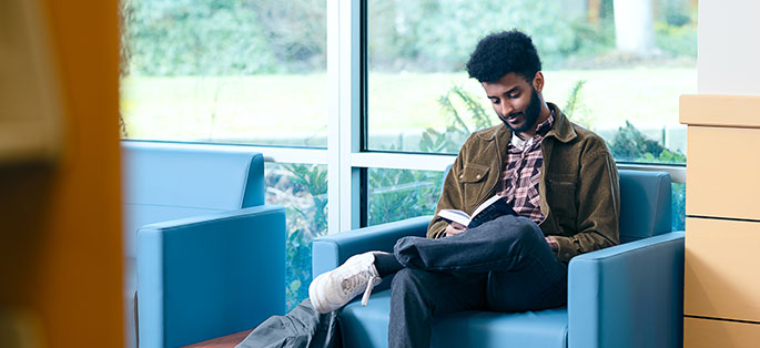 South student sitting and reading in library