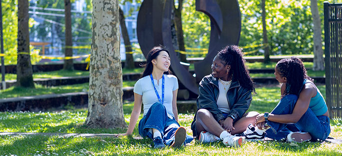 Students sitting outside at Seattle Central smiling and talking in the sun