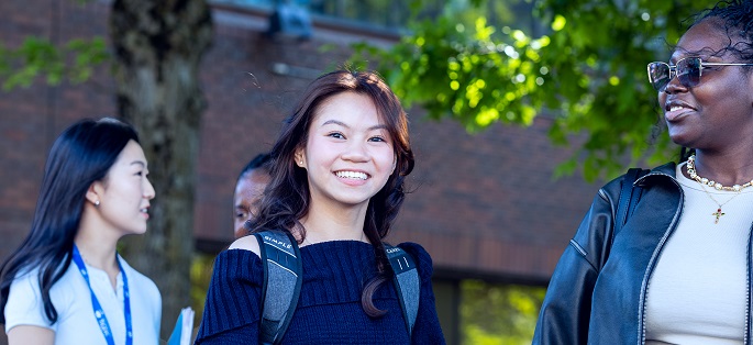 a small, diverse group of students interacting outdoors on Seattle Central campus