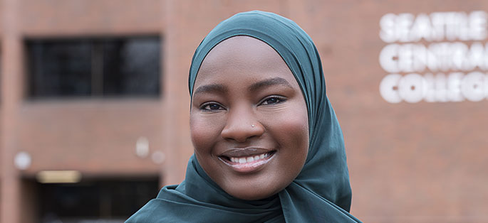 Latifa smiling standing in front of Seattle Central exterior