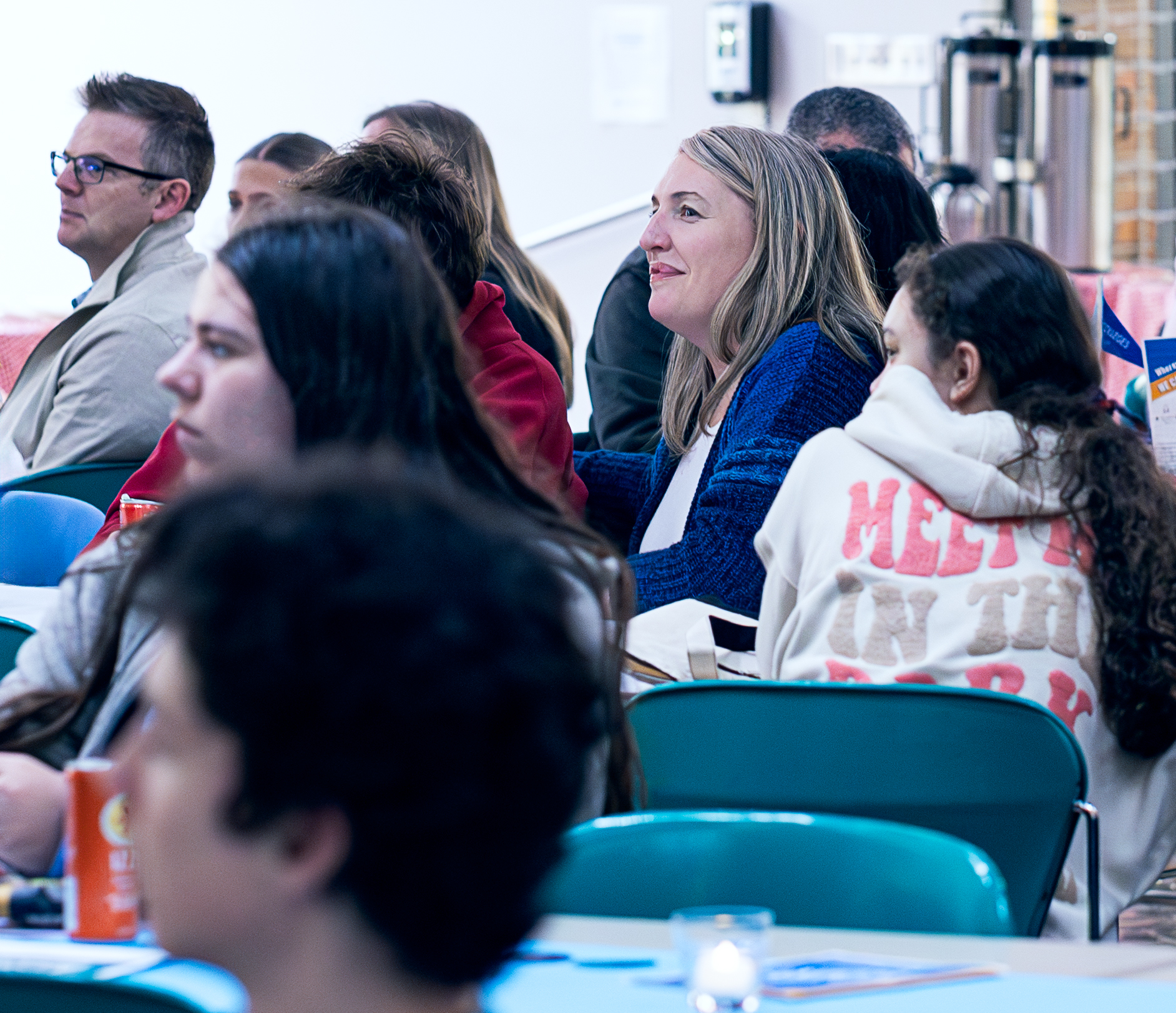 Attendees and family members listening to speakers