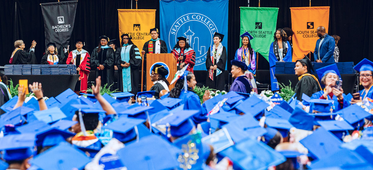 commencement stage with stage party among a sea of graduates