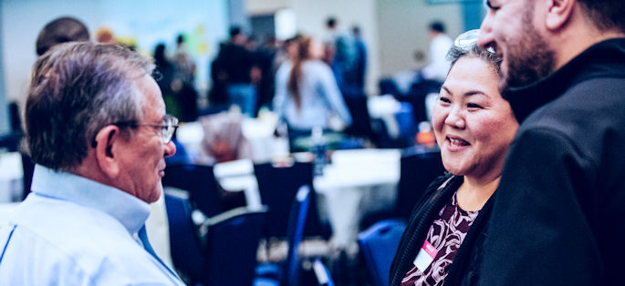 three employees in a discussion at a campus event at South Seattle College