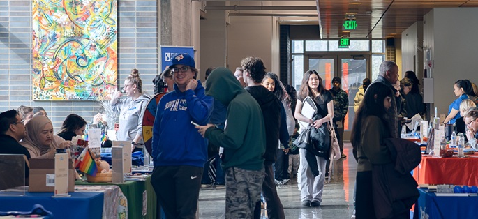 a diverse group of people interacting while attending an event in the hallways of Georgetown Campus