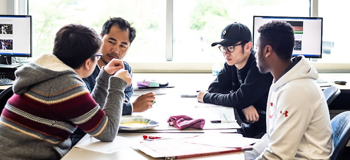 a diverse group of four students interacting in a classroom setting