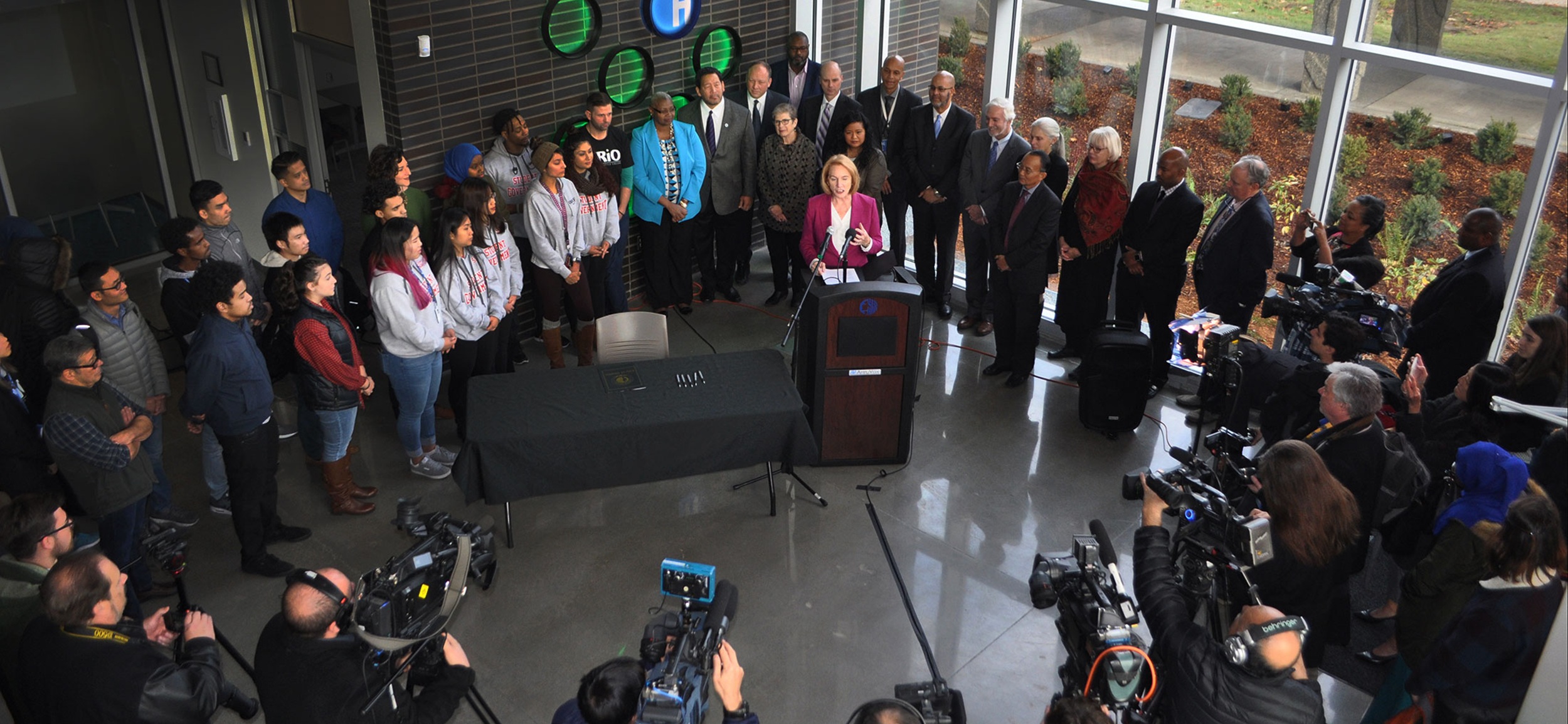A press conference with speakers and the press with cameras and microphones