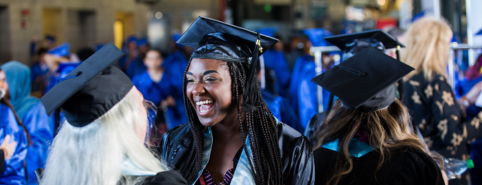 Graduates smiling as they prepare for commencement