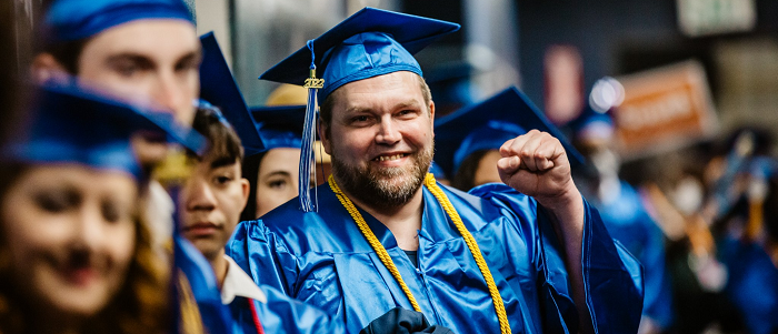 Graduates in caps and gowns lining up for commencement.