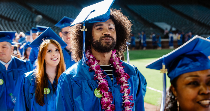 Students in caps and gowns entering the commencement ceremony in the processional.