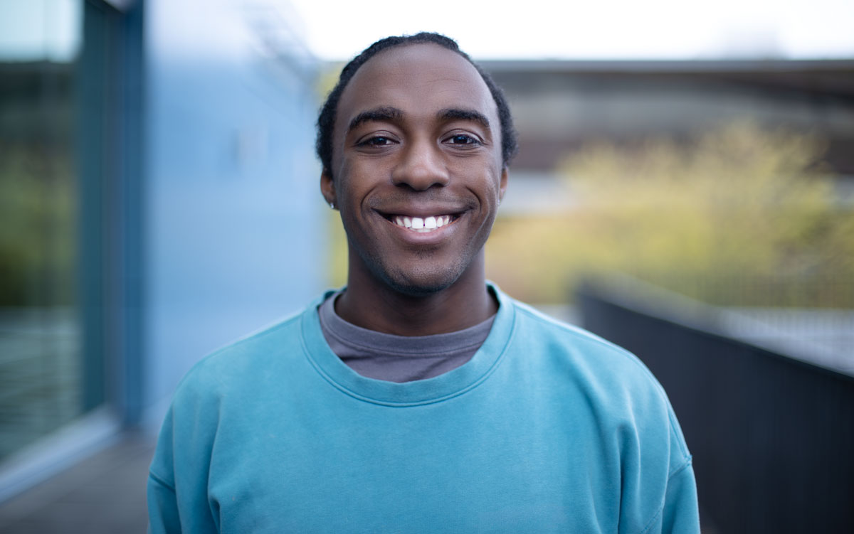 Vladimir Andral smiling in front of North Seattle College outdoor space