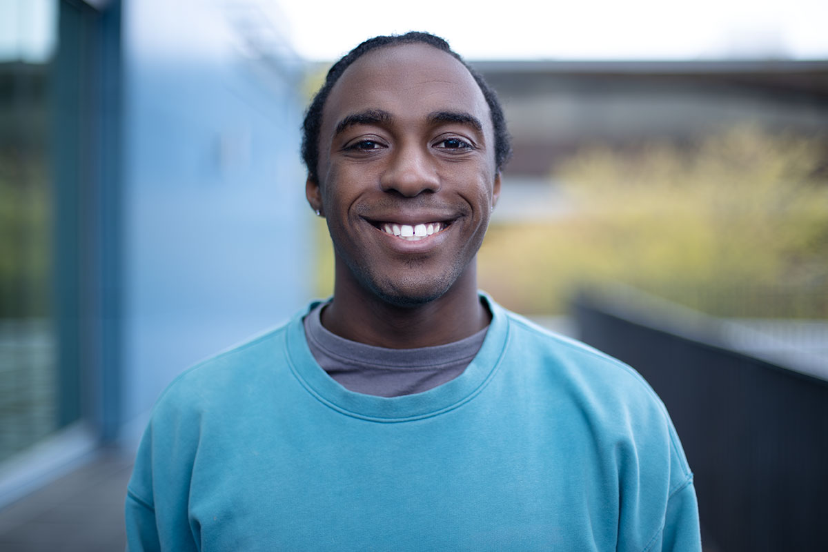 Vladimir Andral smiling in front of North Seattle College outdoor space