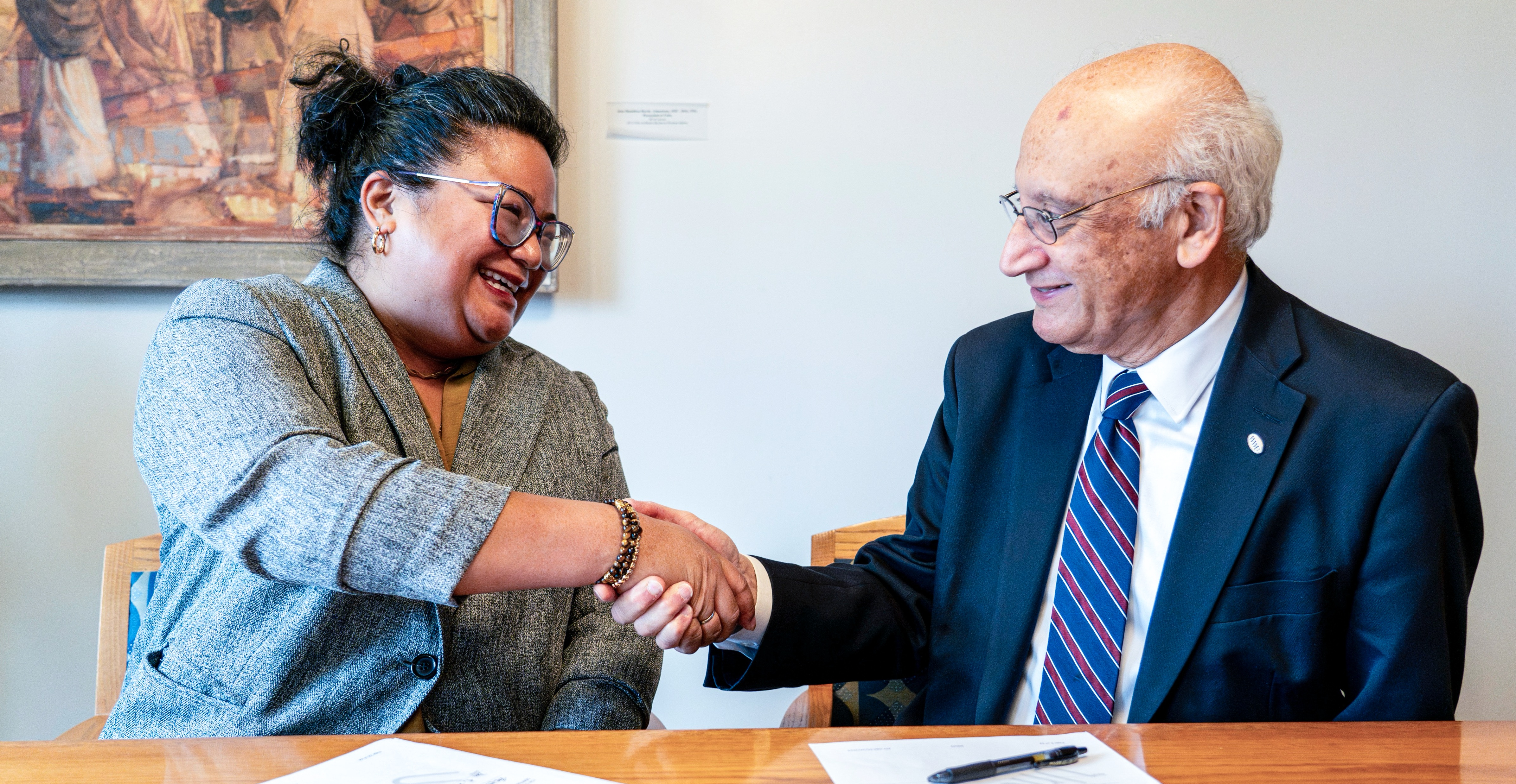 Seattle Colleges Chancellor Rosie Rimando-Chareunsap and Western Washington University President Sabah Randhawa shaking hands at agreement signing